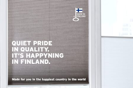 Närbild på en persienn med en logotyptext om kvalitet och finskt hantverk, samt en ikon för Finlands flagga.