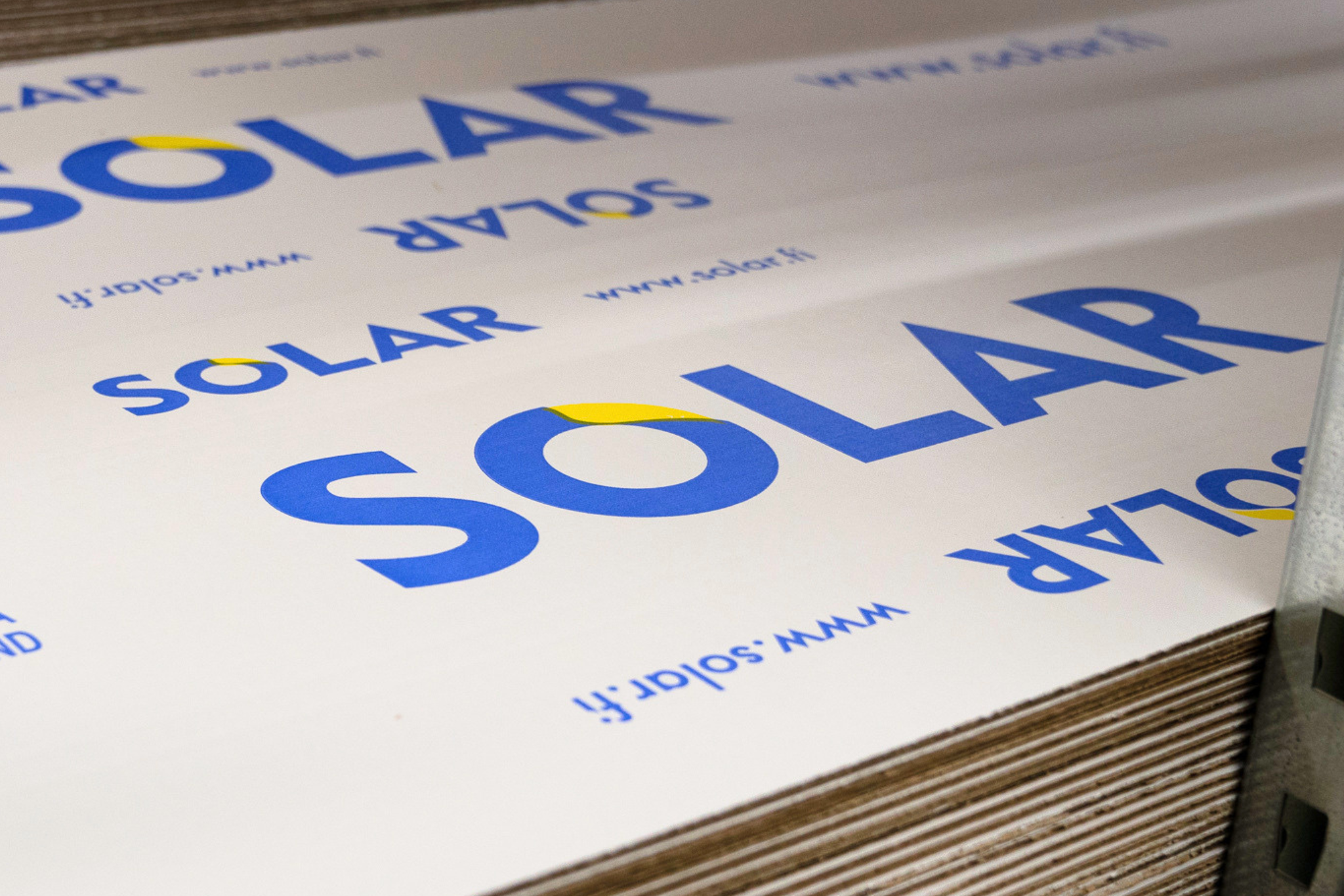 Närbild på staplade förpackningsark med Solar-logotypen och varumärkesprofilering, redo för produktförpackning.
